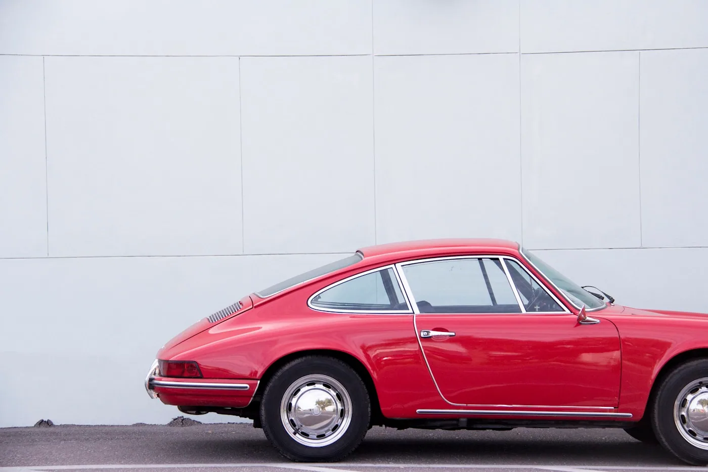 Porsche 911 de los años sesenta, de perfil contra un muro blanco